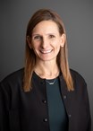 headshot of a smiling brown-haired woman wearing business professional clothing